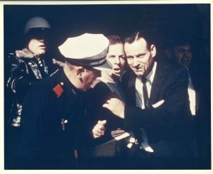 Dallas police officers arrest Lee Harvey Oswald and remove him from the Texas Theater in Oak Cliff.