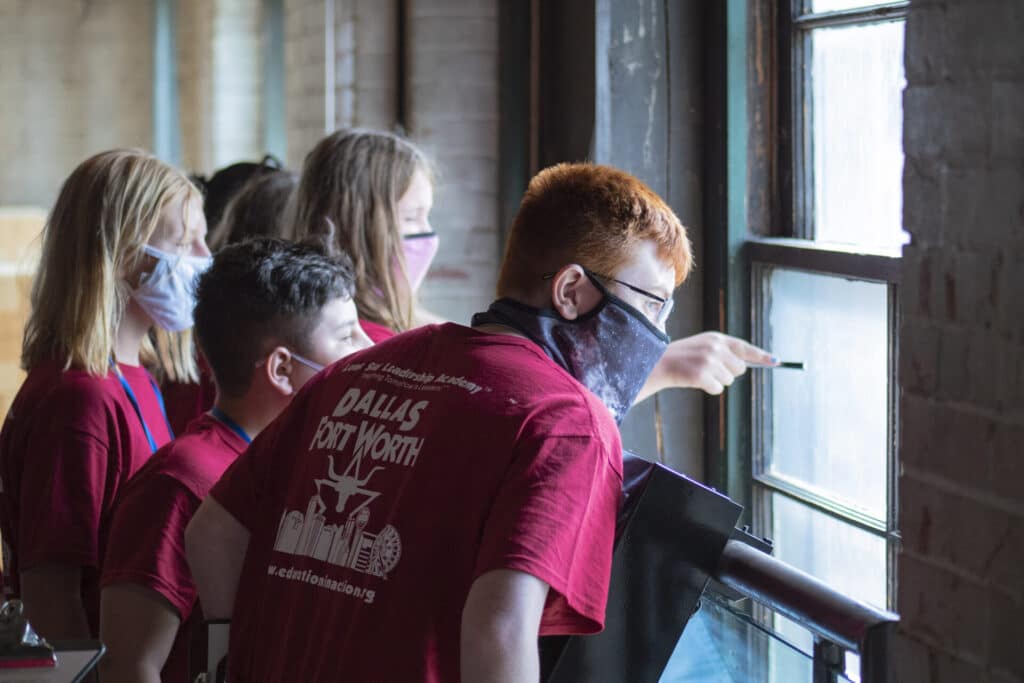 Los estudiantes miran por las ventanas de la sexta planta de la exposición.